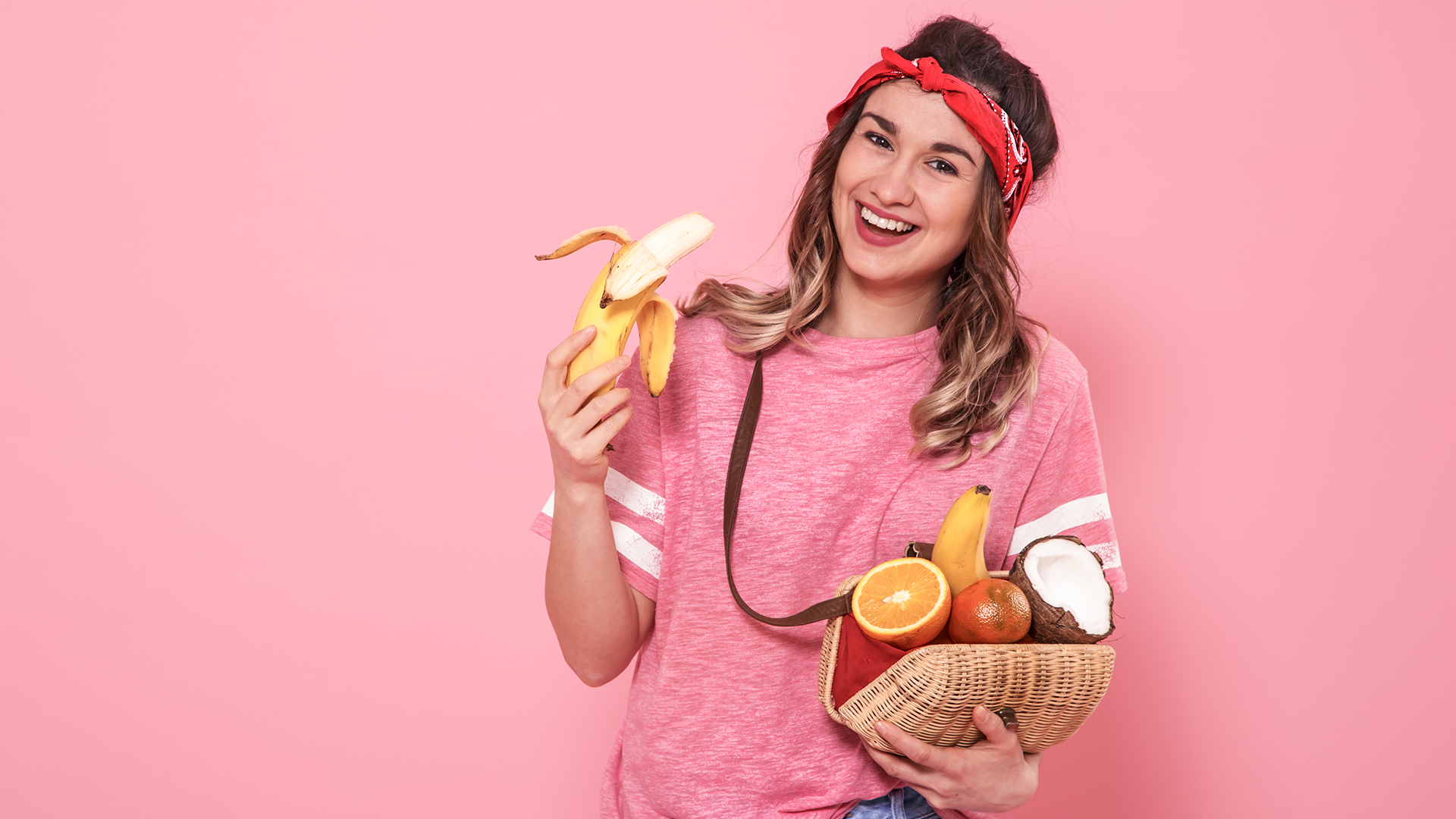 A happy woman holding some fruits